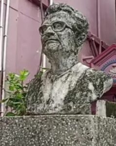 A commemorative bust of Dasarathi Tah, wearing glasses